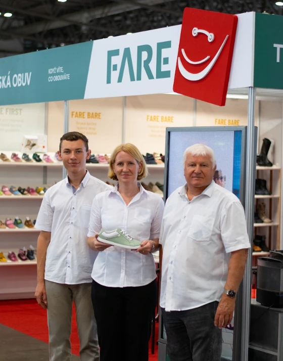 Drei Mitglieder der Familie Šůstek am FARE-Messestand mit Kinderschuhen